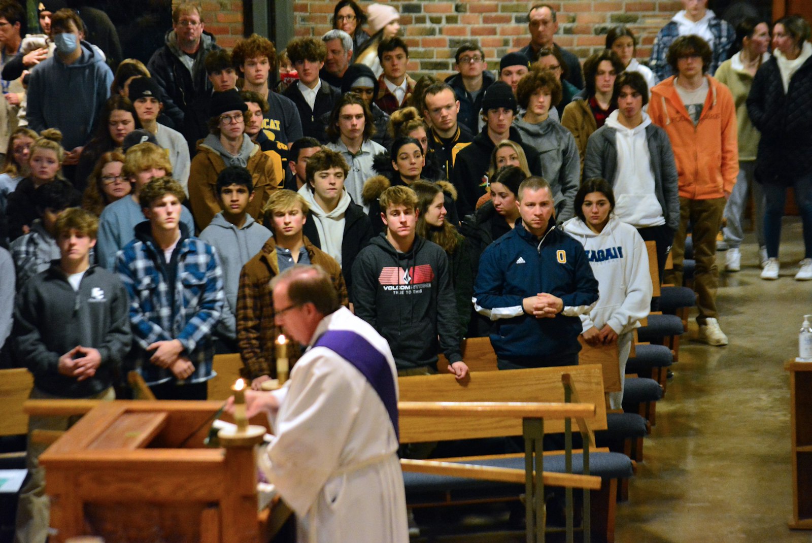 Oxford High School students, staff and parents listen as St. Joseph Deacon John Manera proclaims the Gospel. The church, which seats nearly 1,000 people, was filled during the community-wide Mass.