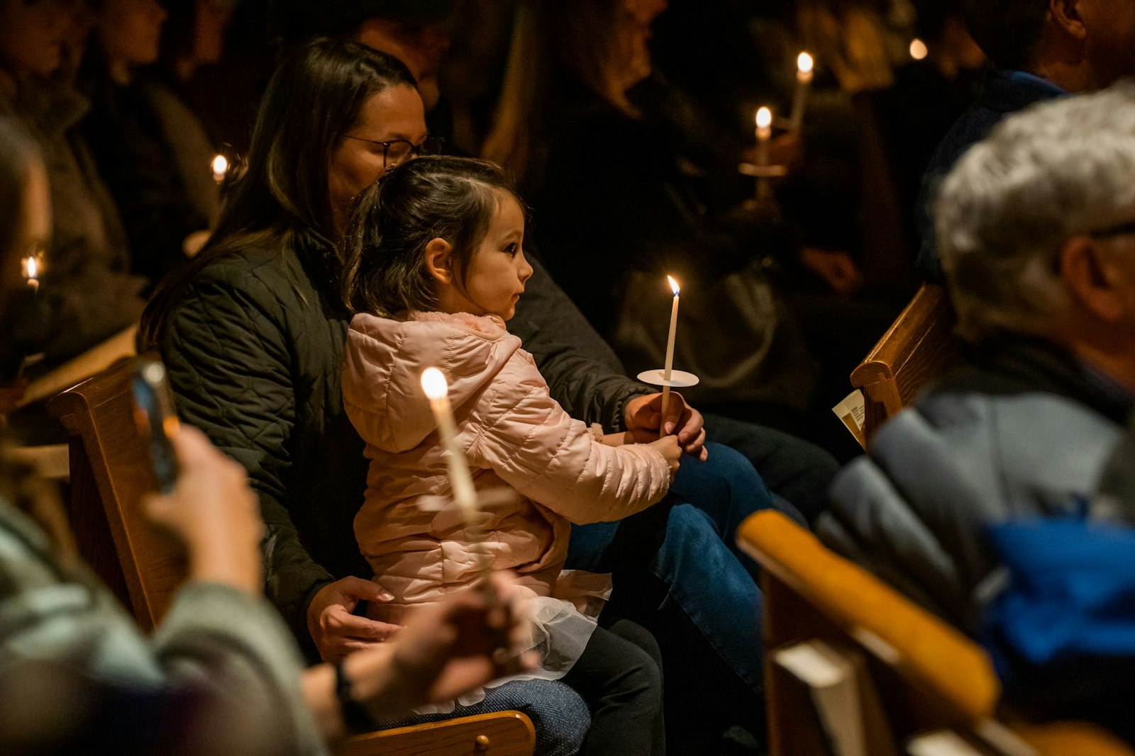 A young girl holds a candle during a Christmas concert and memorial vigil for victims of the Oxford High School shooting Dec. 5 at St. Joseph Parish in Lake Orion. (Valaurian Waller | Detroit Catholic)
